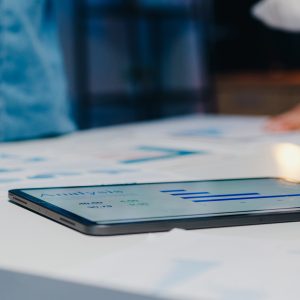 Gruppo di ricercatori che esamina grafici su un tablet in un ambiente aziendale.