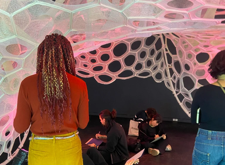 Partecipanti del Laboratorio della mostra Living Structures si sono raccolte/i sotto l’installazione Polythread di Jenny Sabin